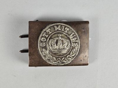 une vieille boucle en argent ornée d'une couronne, sur un fond blanc