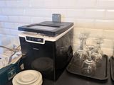 un plan de travail noir avec un micro-ondes et un plateau de beignets