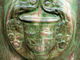 a close up of a green vase with a bird on it
