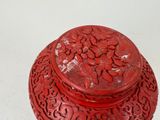 a red box with a lid that has flowers on it