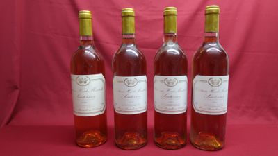 four bottles of wine are lined up on a pink background