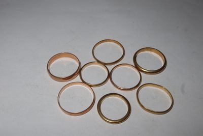 a pile of gold rings on a white surface