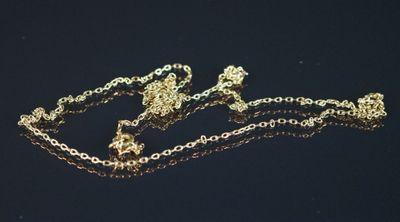 une chaîne en or ornée d'une couronne, posée sur un fond noir
