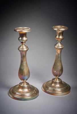 paire de chandeliers anciens en laiton sur fond gris