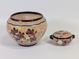 un petit vase avec un couvercle posé à côté d'un autre, plus petit