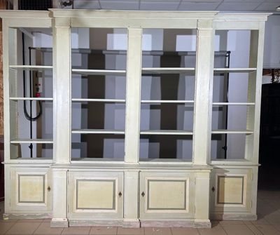 une bibliothèque blanche aux portes vitrées, placée au milieu d'une pièce