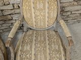 two chairs that are next to each other in front of a stone wall