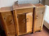 a wooden cabinet with two doors and a radiator in the corner