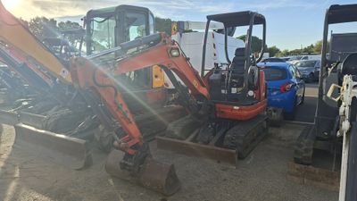 an image of a small excavator parked in a parking lot