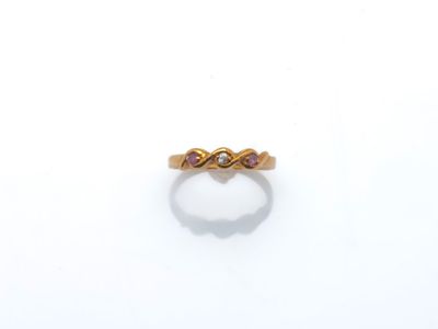 un gros plan d'une bague en or sertie de deux pierres roses