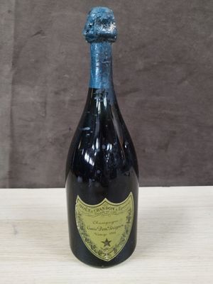 une bouteille de vin vide posée sur une table en bois