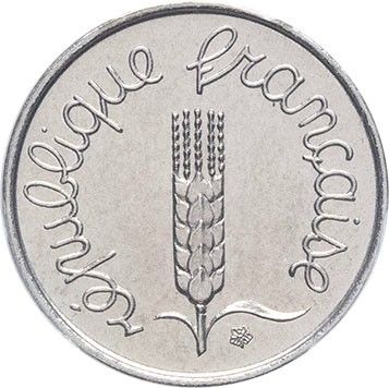 a close up of a coin with a plant on it