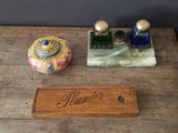 an old wooden table topped with two bottles of perfume and a wooden plaque