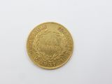 une pièce d'or sur une surface blanche avec un fond blanc