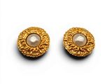 une paire de boucles d'oreilles en or et perles sur fond blanc