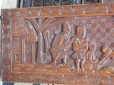 a wooden carving of a man and a child on a bench