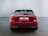 the back of a red car in a room with a white wall