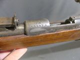someone is holding a gun with a wooden frame and a metal handle
