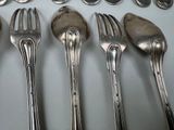 a lot of silver spoons and forks on the table
