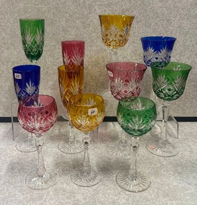 de nombreux verres en cristal de différentes couleurs posés sur une table