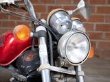 a red motorcycle parked in front of a brick wall