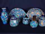 de nombreuses pièces de poterie bleues et vertes disposées sur une table