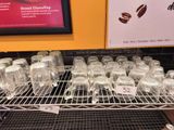 many glasses of water on a rack in a store