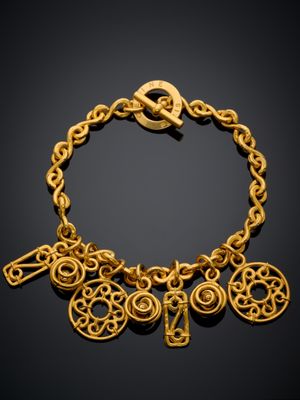 gros plan d'un bracelet en or sur fond noir
