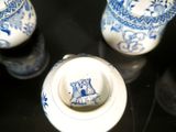 three blue and white vases sitting on a black table