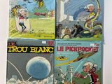 four comic books on a table with a white background