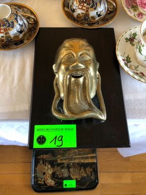 une statue en or représentant un homme barbu, posée sur une table