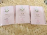 three packets of pink soap sitting on top of a wooden table