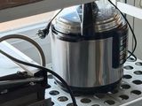 un mixeur argenté et noir posé sur une étagère dans une cuisine