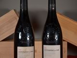 two bottles of wine sitting next to each other on a table