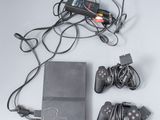 une console de jeux vidéo et deux manettes posées sur la table