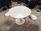 a white table and four chairs in a room