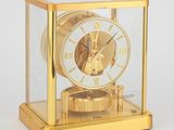 une horloge en or avec l'image d'une femme, exposée dans une vitrine
