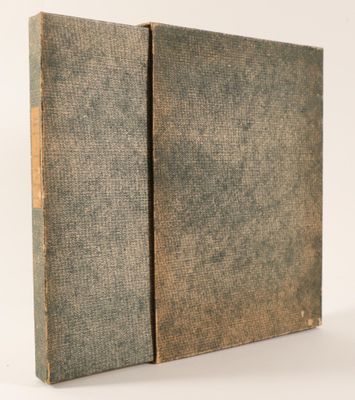 an old book sitting on top of a table next to a white wall