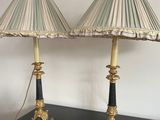 une paire de lampes noires et dorées, munies d'abat-jours, posées sur une table