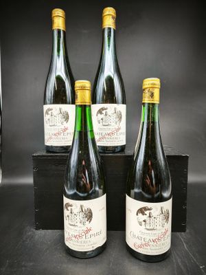 quatre bouteilles de vin sont posées dans une caisse en bois sur une table