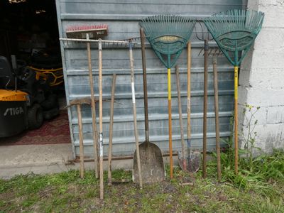 a lot of garden tools that are outside of a garage