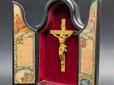 une image représentant un crucifix dans un écrin rouge orné d'une croix dorée