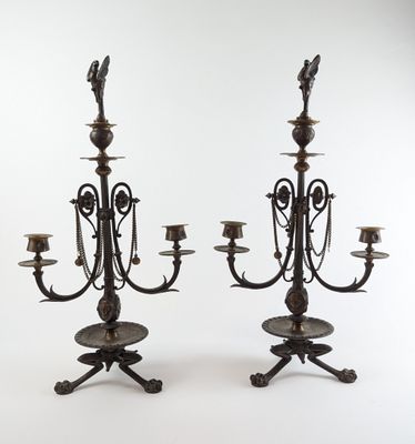 une paire de chandeliers anciens en laiton avec des bougies posées sur des socles