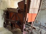 une vieille charrette en bois avec un siège en bois dans une pièce