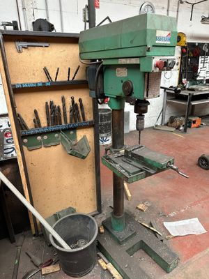 a machine that is sitting in a garage with tools on it