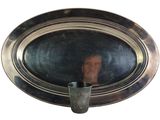 a reflection of a man in the mirror of a silver plate