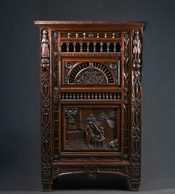 une vieille armoire en bois ornée de sculptures sur la façade