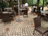 des tables et des chaises dans un coin jardin agrémenté d'arbres et d'une borne d'incendie
