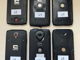 six cell phones are lined up on a table with labels on them
