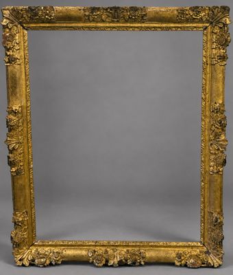 un miroir orné d'un cadre doré sur fond gris